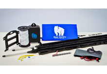 Load image into Gallery viewer, Base Camp model Bear Sentry electric fence contents displayed, including blue bag with logo, polywire spool, ground stake, energizer, 6 posts, connector cables, pouch and yellow white warning signs.